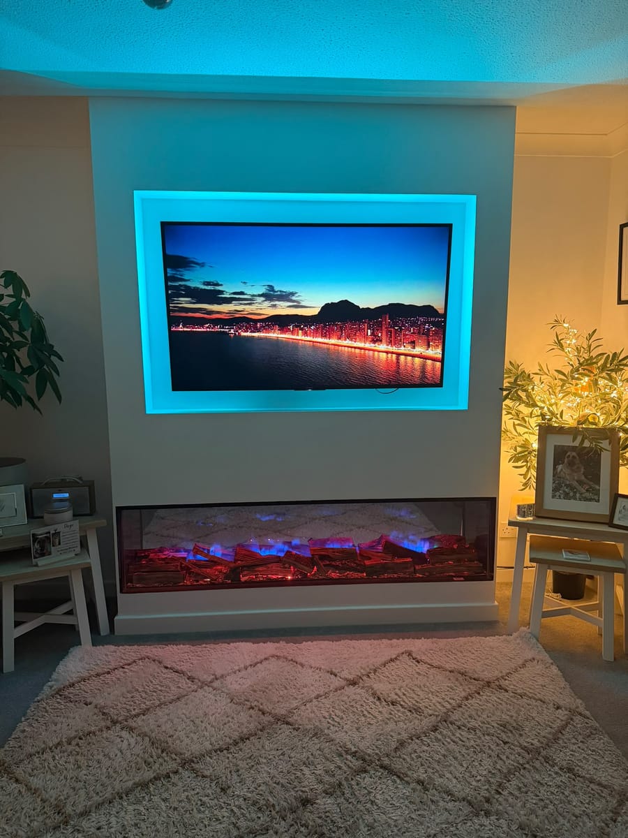 Media wall with turquoise lighting around the TV recess