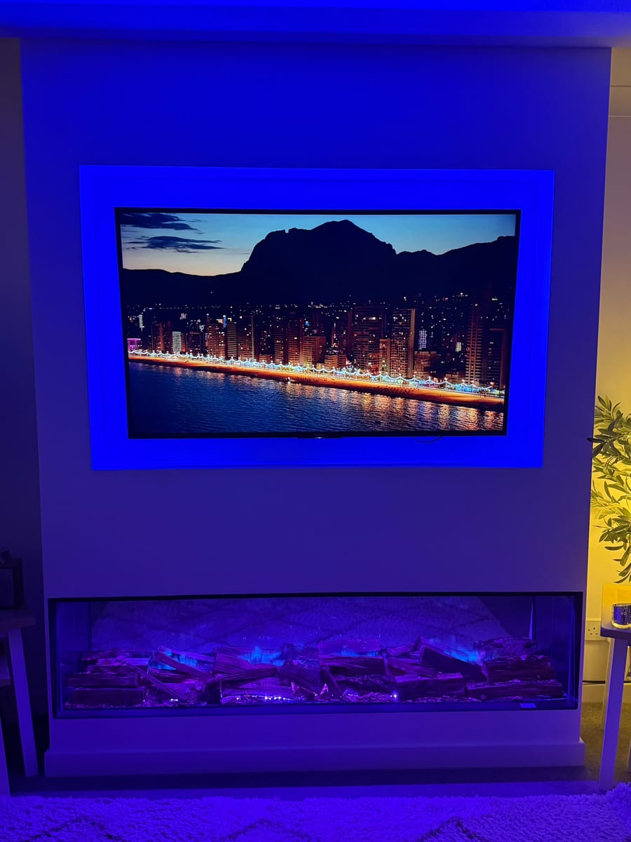 Media wall with blue lighting around the TV recess