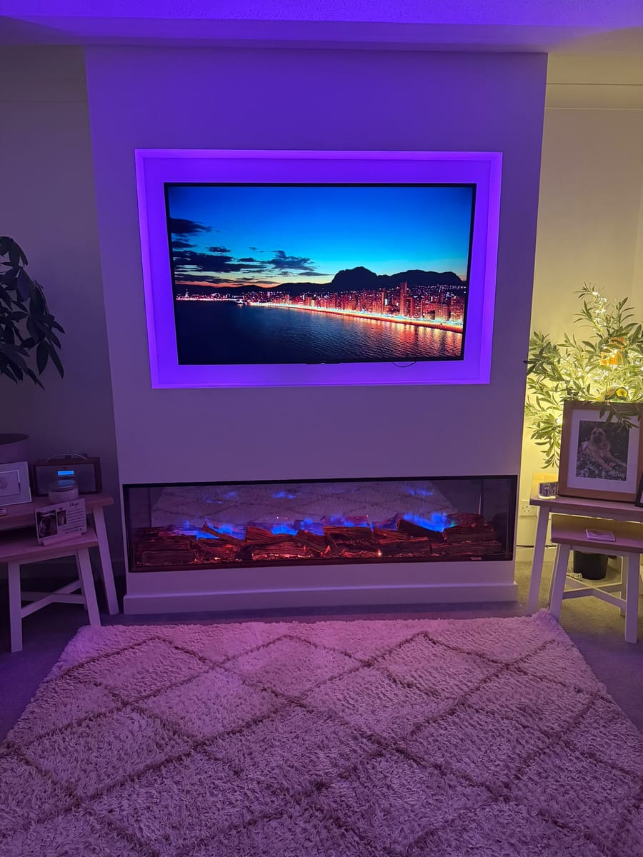 Media wall with purple lighting around the TV recess