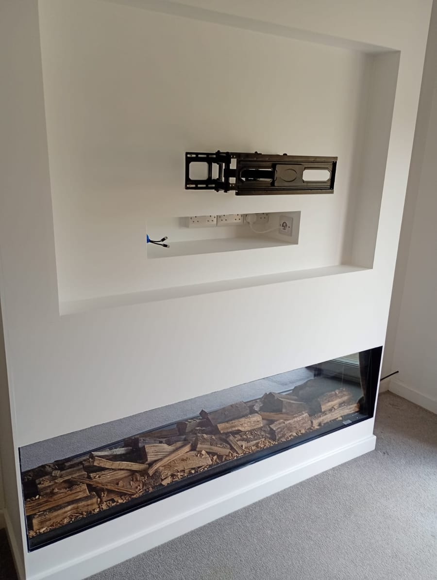 Painted media wall with the TV bracket, sockets and cable shelf in the recess