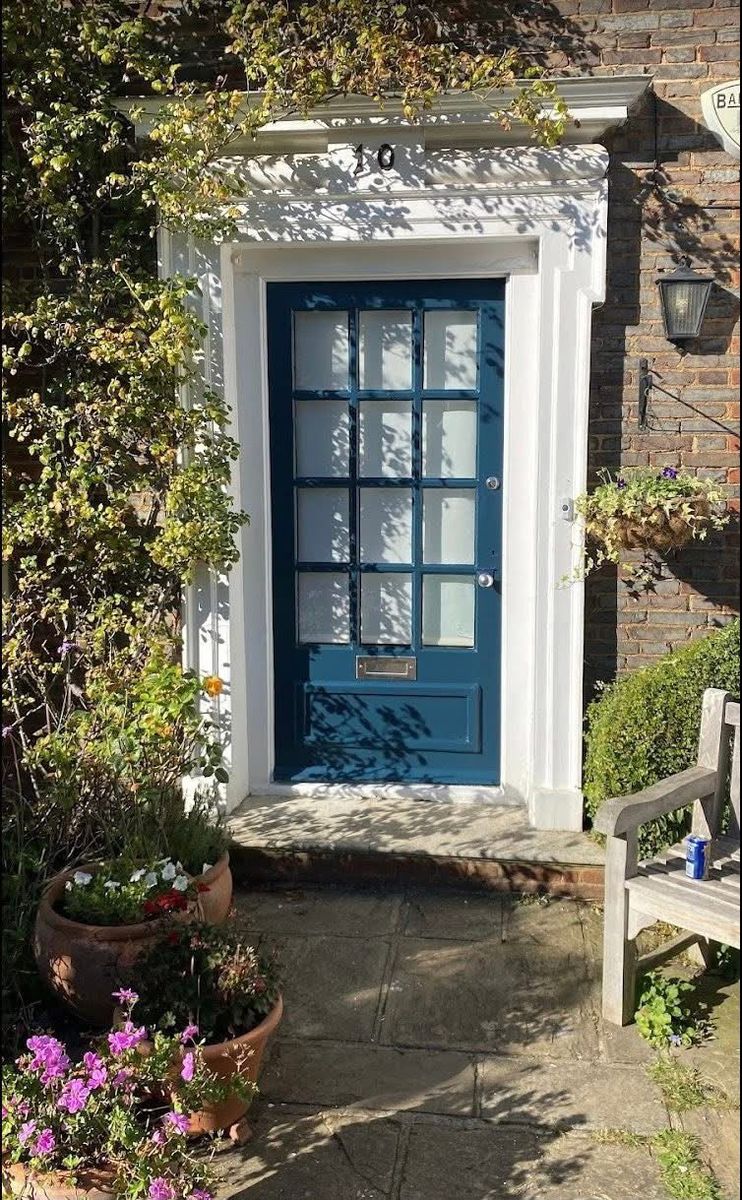 Teal front door with a white painted surround