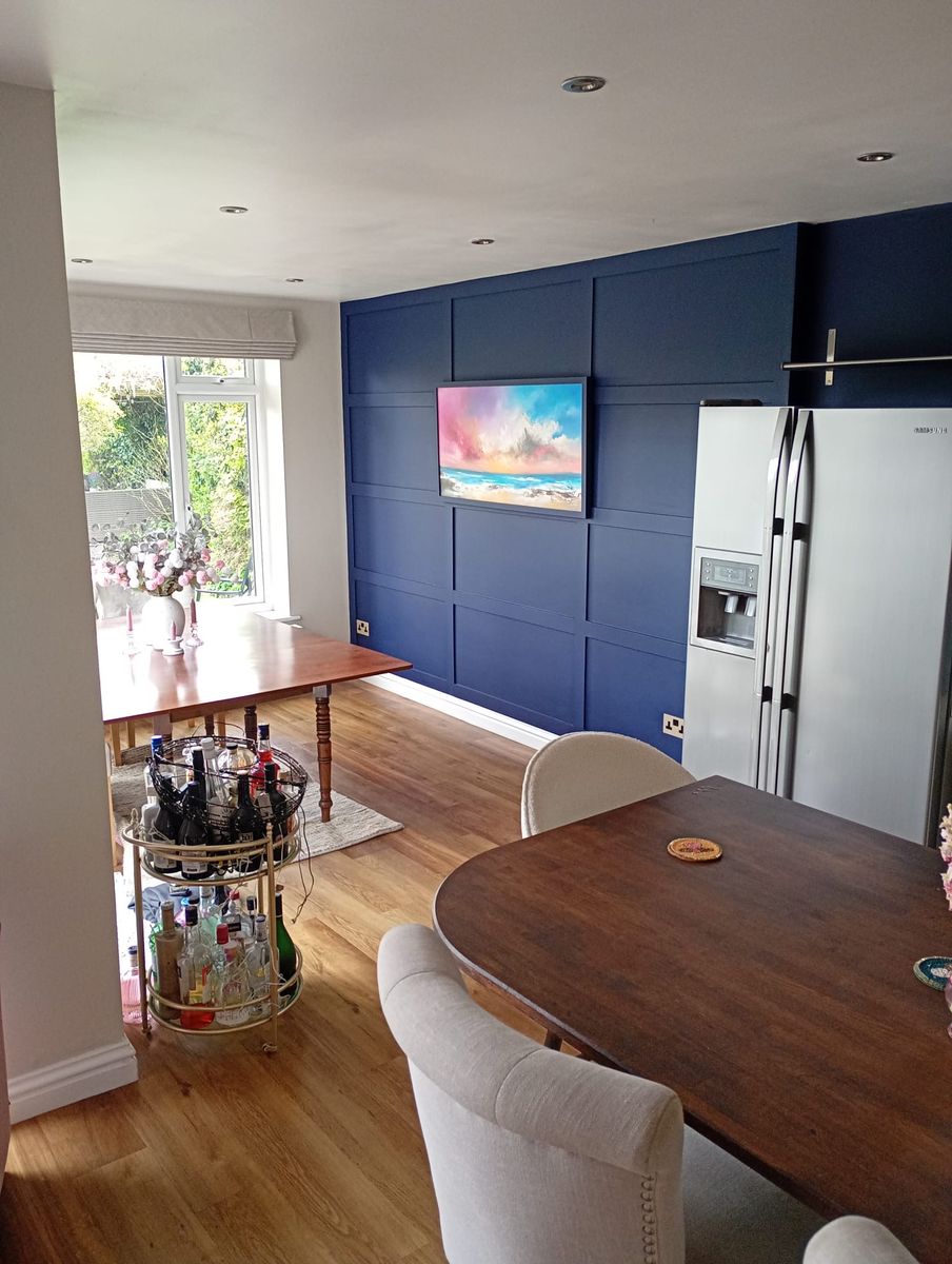 Dining room with navy panelled walls and white ceiling