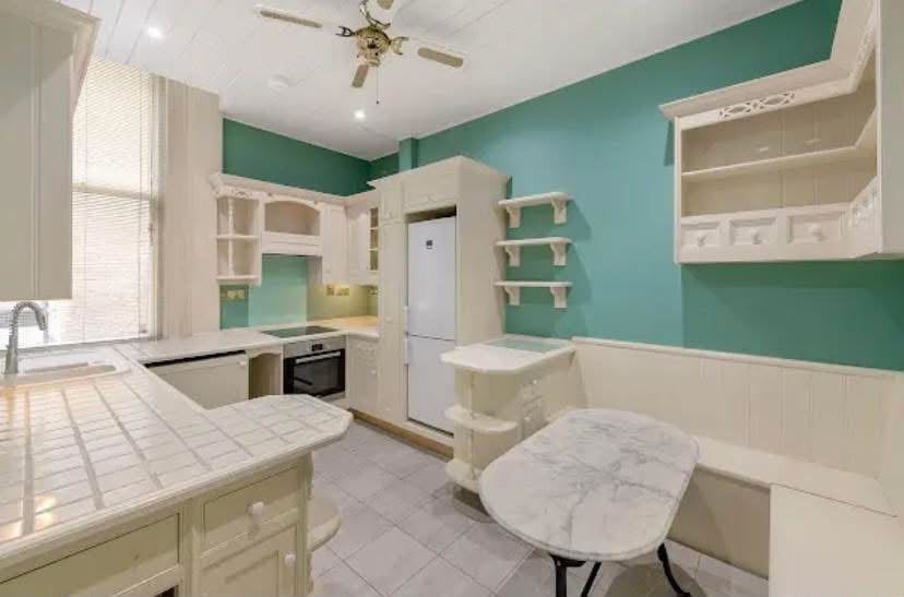 Kitchen with teal walls and cream units