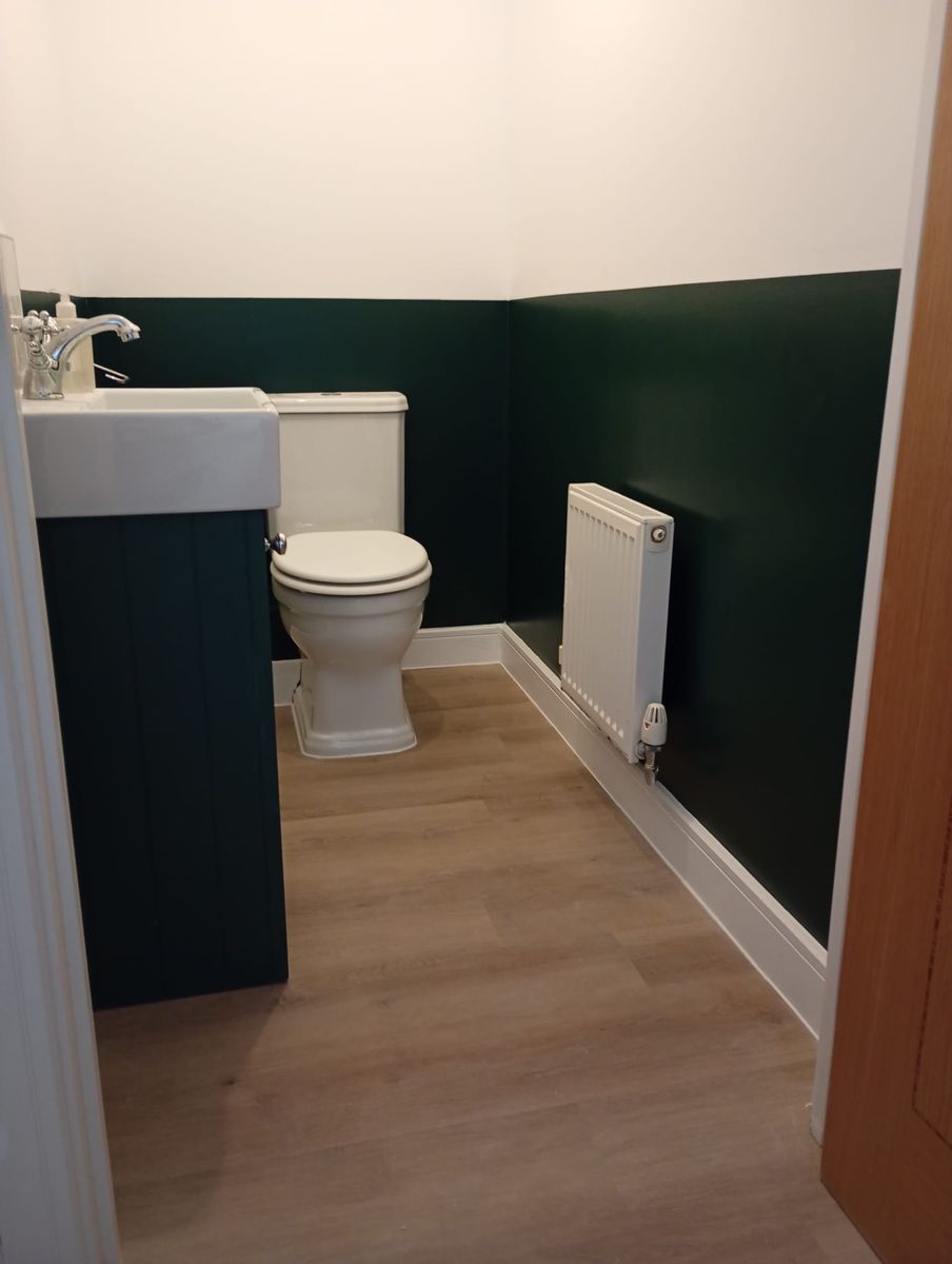 Dark green cloakroom with white woodwork